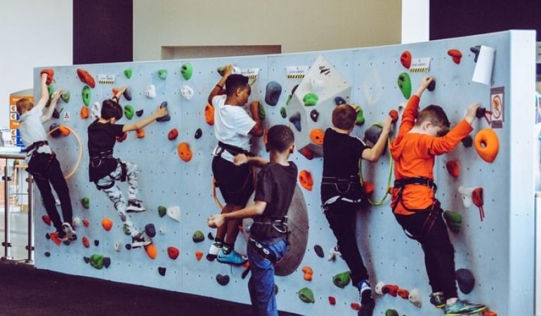 Decoratieve foto van leerlingen die een klimmuur beklimmen